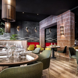 Fauteuil design Aleta avec accoudoirs de Viccarbe dans un restaurant| Aiure