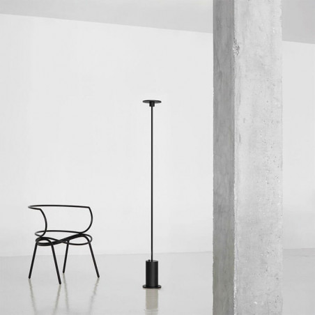 Lampadaire noir Up d'Arkoslight à coté d'une chaise | Aiure