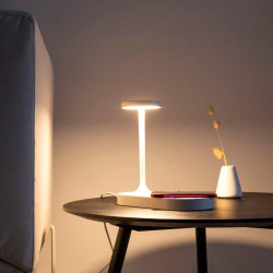 Lampe à poser blanche Ceres allumée sur une table basse. Mantra | Aiure