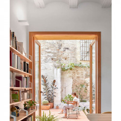 Rec Mini wall sconce in open common area with window. By Arkoslight | Aiure